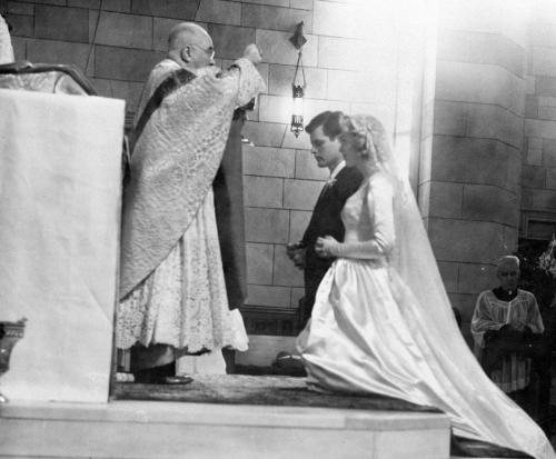 Nov. 11, 1958, Edward M. Kennedy, and Joan Bennett, kneel on the altar and receive communion from Fr