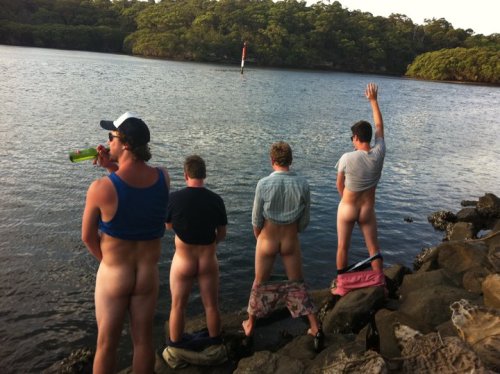 Four drunk guys strip down their pants, and piss into the lake.