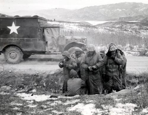A Truck Moves Past Marines Trying To Keep Warm, Chosin Reservoir Area, Ca December 1950. 