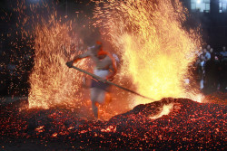 picaet:  People walked barefoot across red-hot coals in Qianming Village, China, Friday.  Xu Xiaofeng 