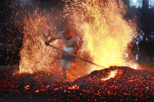 picaet:  People walked barefoot across red-hot coals in Qianming Village, China, Friday.  Xu Xiaofeng 