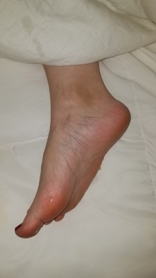 myprettywifesfeet:  My pretty wifes beautiful irresistible little foot poking out of the covers begging to be lotioned.please comment