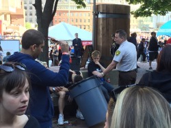 fencehopping:  Good guy cop at Boston Calling holds a garbage can for a guy that over partied.