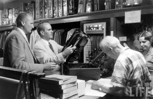 Cincinnati detectives looking for stolen goods in a pawn shop(Francis Miller. 1957?)