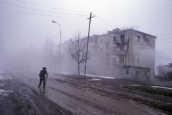 Hogpig:  Nagorno Karabakh. 2005. A Man Walks Past The Half-Empty Apartment Blocks