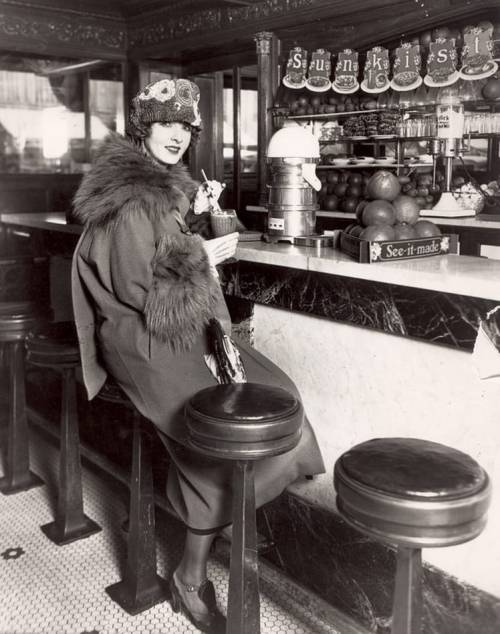 the1920sinpictures:1923 c. photo of silent film star Claire Windsor at a soda fountain. From Forgotten Splendour, FB. https://painted-face.com/