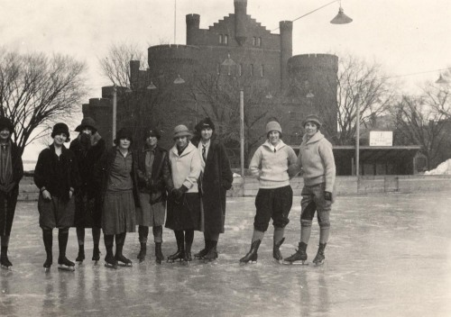 Women pose on a skating rink in front of the University of Wisconsin Armory and Gymnasium, also call