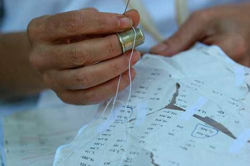 Elena del Rivero sewing and patching paper fragments in her studio, in [Swi:t] Home: A Chant, 2001-2