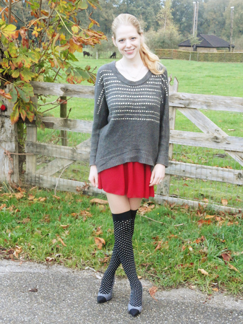 Black otk socks with white polka dots, bight red pleated skirt and loose grey cardigan