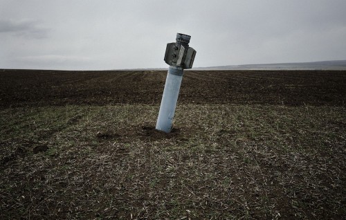 soldiers-of-war: UKRAINE. Dmitrivka. April 7, 2015. An unexploded rocket remains embedded in a field