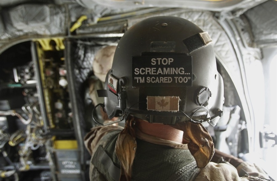 error888:  A Canadian Army crewman stands inside a CH-47 Chinook helicopter flying
