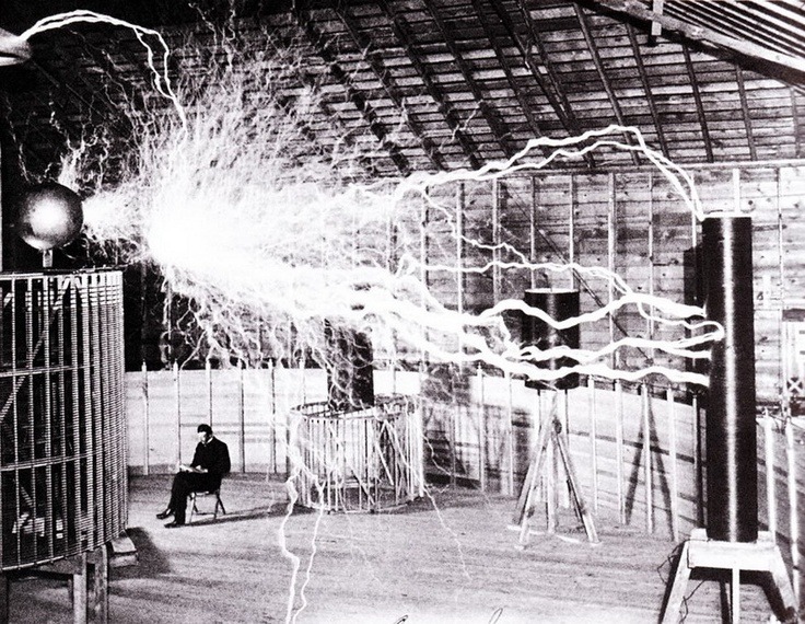 Multiple exposure publicity picture of Tesla sitting in his Colorado Springs laboratory