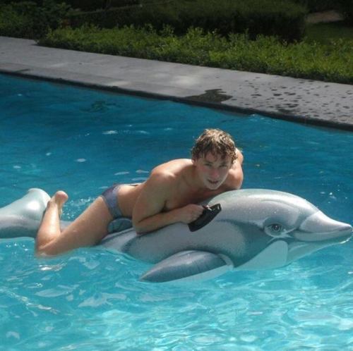 speedosandpooltoys:Cute guy and his Inflatable dolphin
