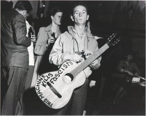 Woody Guthrie with his guitar (1941)