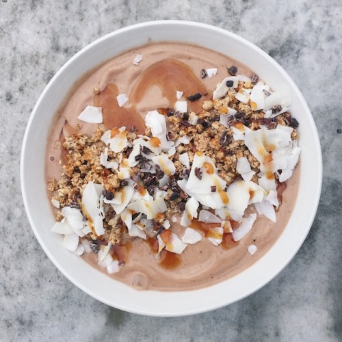 choc nicecream topped with caramel sauce, coconut chips, cacao nibs and granola