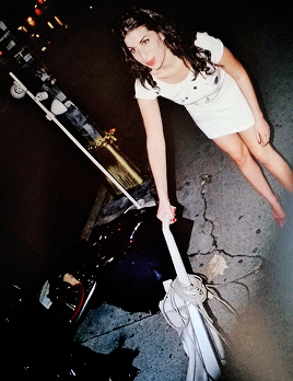 amyjdewinehouse:Amy Winehouse washing her guitar and vacuuming the pavement, 2003