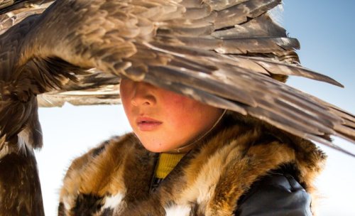 morethanus-life:A child beneath the wing of his golden eagle in the Altai region in western Mongolia