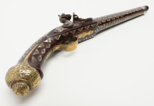Ornate pearl and brass mounted flintlock pistol originating from North Africa, 19th century.