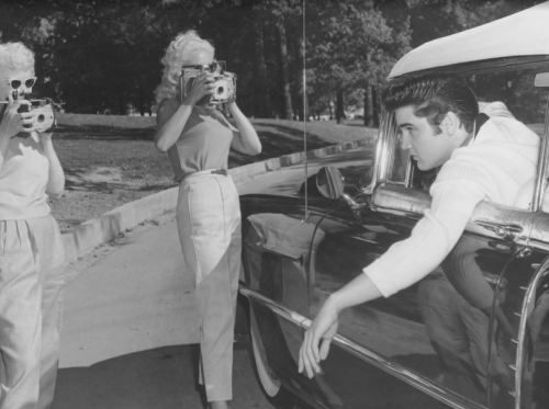 Always the ladies&rsquo; man, Elvis poses for two women with cameras in the driveway at Gracelan