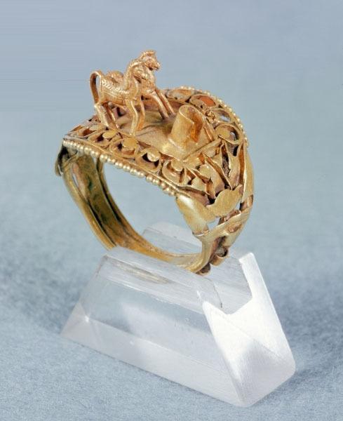 historyarchaeologyartefacts:Golden ring decorated with lotus flowers and adorned with two horses. Be