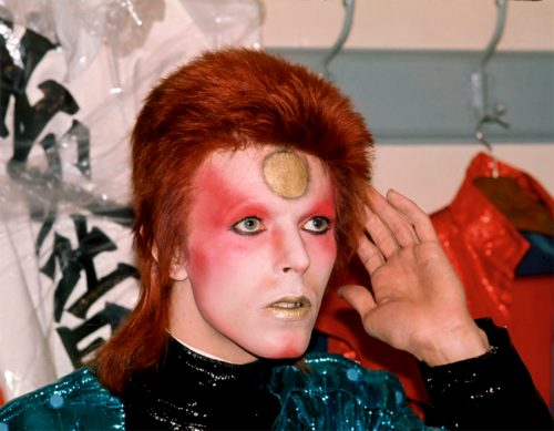 soundsof71:  David Bowie, 1973: no eyebrows, classic eyeliner game, gold lipstick on point, by Mick Rock