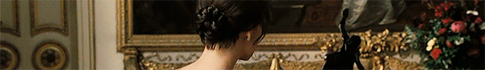 Gif de uma cena do filme Orgulho e Preconceito. Gif de Elizabeth bisbilhotando a mansão de Darcy. Ela está indo em direção a um vaso de flores.