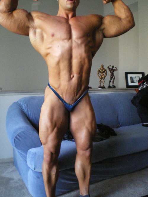 Big Muscle Body In Tiny Posing Trunks. His Small Bulge Suggests He Has Had His Package Reduced.
