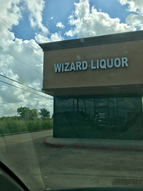 greyfaerie: image: an empty storefront, photographed from inside a car. the sign reads, “wizard liqu