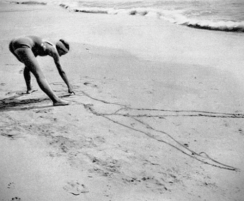Irina Baronova drawing a self-portrait on the beach at Juan-les-Pins, 1934