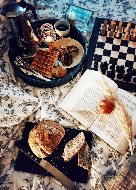 pain découpé sur une planche, gaufre, livre ouvert, pomme, échiquier