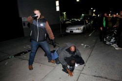 woggywoowoo:  boingboing:  Undercover cop aims gun at photographer at Oakland protest of police killings In this photo from a protest in Oakland, an undercover police officer aims his loaded gun directly at a Reuters photographer.  I think the icing on