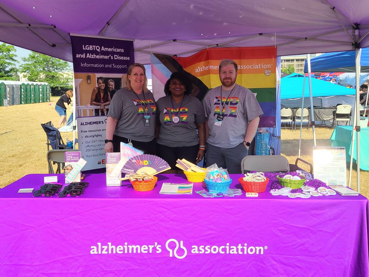 Volunteers and Association staff pose for a picture at a booth at the Indy Pride festival.