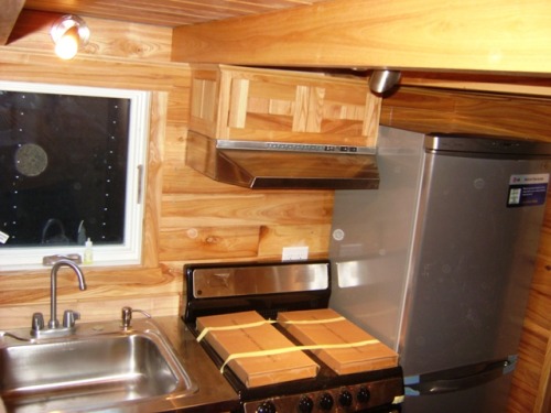 tinyhouseamerica:  Another AMAZING tiny house!  This home is built on a standard trailer and uses the galley floor plan to fit in full sized washer and dryer (the shiny red boxes), full sized kitchen appliances, and a bathroom with an incinerating toilet!