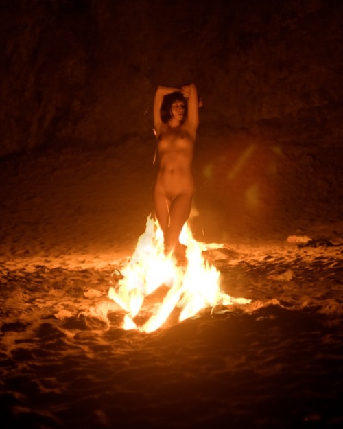 Nude male fire dancer