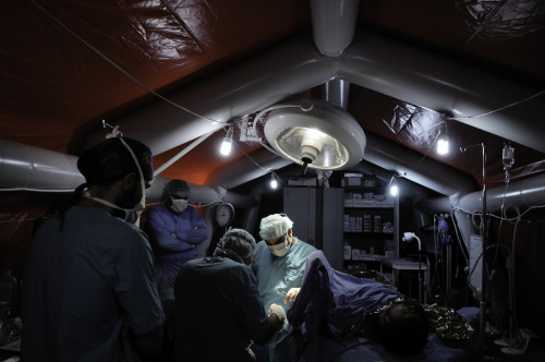 pretentiouspretenses:In Syria, MSF surgeon Steve Rubin treats a patient in an inflatable operating t