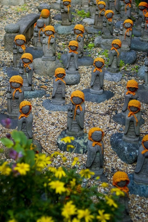 sixpenceee:  A Jizo is a Japanese god who’s thought to protect children who die before their parents. There more than one million small Jizo statues spread throughout Japan at temples or along the side of roads. The Japanese care for these statues and