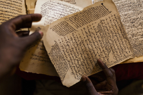 Malian copyist Boubacar Sadeck consults an ancient manuscript on July 29, 2013 in Bamako, Mali.&gt; 