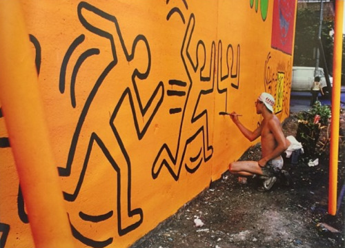 twixnmix:Keith Haring painting a mural on Houston Street and Bowery in New York City, 1982.  (Photos