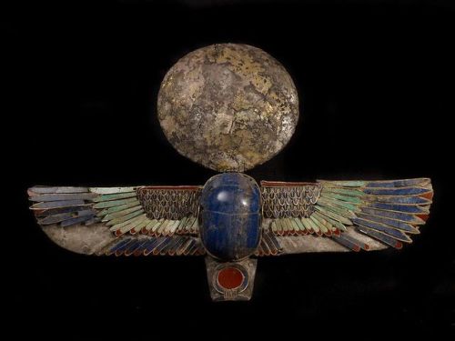 egypt-museum:Silver Winged ScarabThis winged scarab made on a silvered background, inlaid with lapis