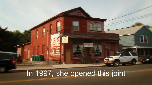 90% sure it's a car parked on the side of a building. Caption: In 1997, she opened this joint