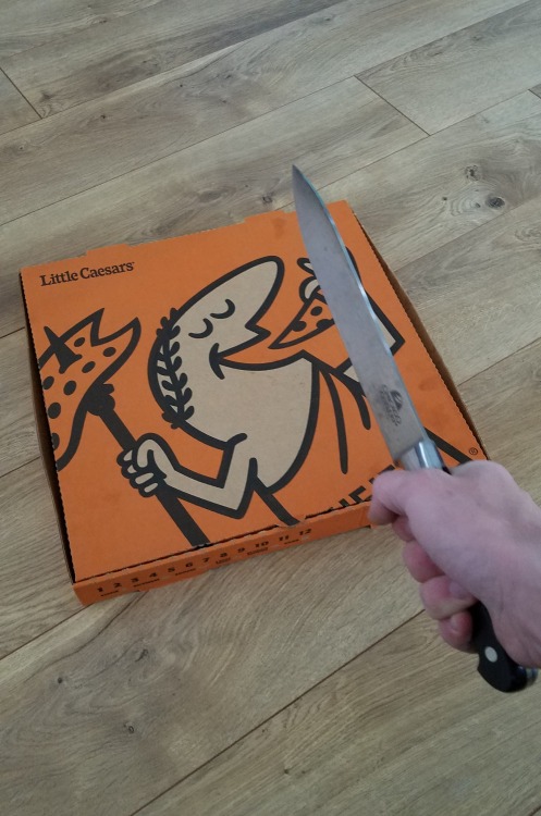 pathos-logical:assdare:  assdare:Soon™    [Image ID: Image one is a picture of a Little Caesars pizza box. A hand is holding a knife out directly above it. Image two is a blurry close-up shot showing the knife being stabbed through the neck of the Little