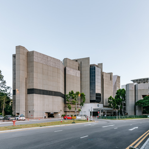 Terraces and pyramidal shape facing the sports field to the south, a closed solid wall façade and a 