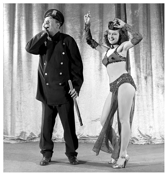 Burly-Q comic Bert Lahr hams it up as a policeman, in a skit with an unknown dancer..