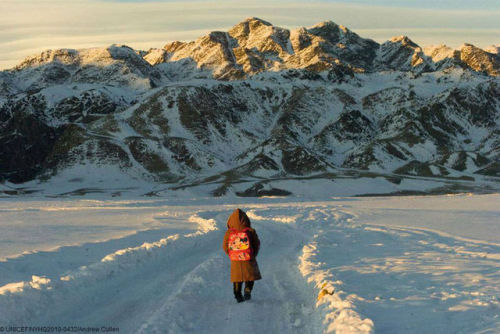 ninewhitebanners:   A Mongolian first-grader with a Mickey Mouse backpack walks home from school, against the backdrop of the Altai mountains. Photo by Andrew Cullen. 