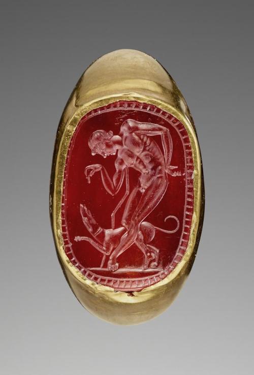 historyarchaeologyartefacts:Engraved gem (Gold, carnelian) with a youth and his dog inset into a hol