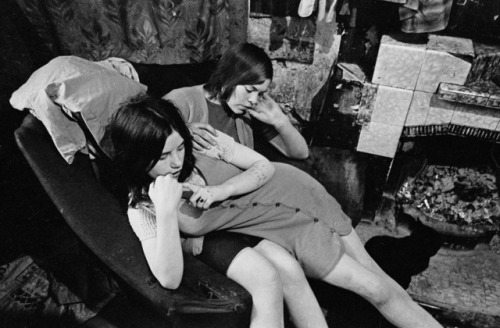 Sisters sharing a chair in a Gorbals slum tenement, 1970. Photo Nick Hedges