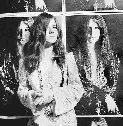 Janis posing in front of Bob Seiddmann poster, 1967.Photography by Baron Wolman.