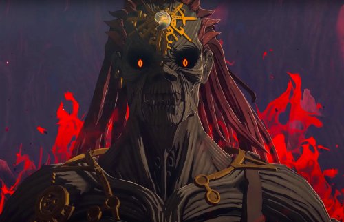 Screenshot from "Legend of Zelda: Tears of the Kingdom" with a mummified, greenish skin-piercing glowing eyes, and red flames behind him. His body is almost skeletal, only muscle fibers with no skin with a jewel encrusted crown on his head.