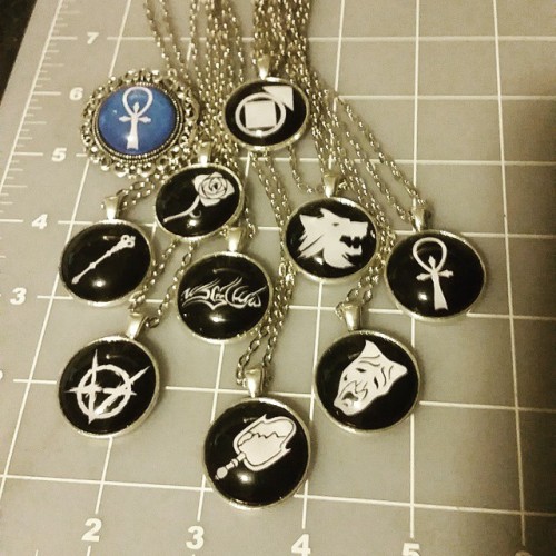 mmbaroque:  Here they are, all done.  All the #Camarilla clans plus the Ankh. The blue one is a fancy pin. #VtM #vampirethemasquerade #customjewelry #fanjewelry 