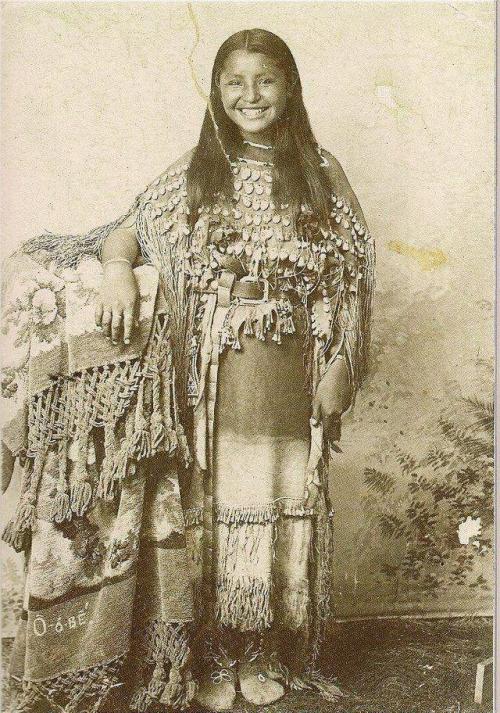 blondebrainpower:This photo is held by the National Museum of the American Indian which is part of the Smithsonian.It is titled Portrait of Young Kiowa Woman, O-o-be’ ca 1894 and this is the information they have for it:Description from a letter of